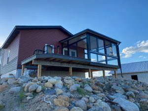 Black studio sunroom with a side deck