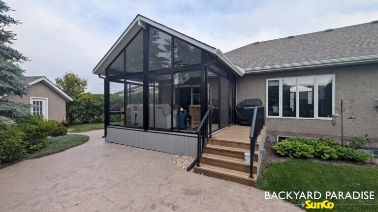 Black gable sunroom with treated lumber landing and black aluminum picket rail installed in Steinbach, Manitoba