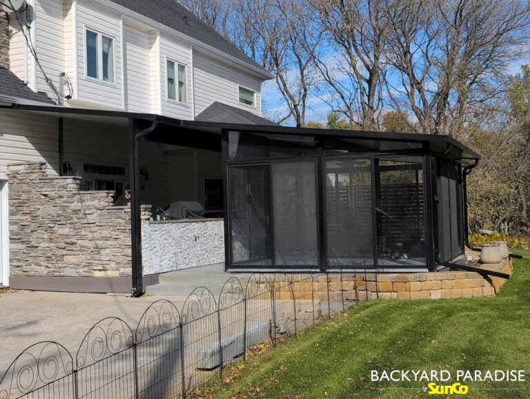 Black studio sunroom with awning and outdoor kitchen privacy wall on composite deck in Landmark, Manitoba