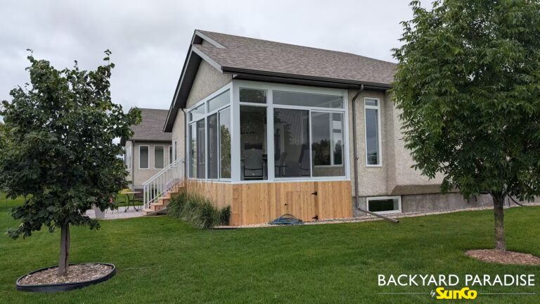 White structural curtain wall sunroom with cedar deck skirt and white aluminum rail in Headingley, Manitoba