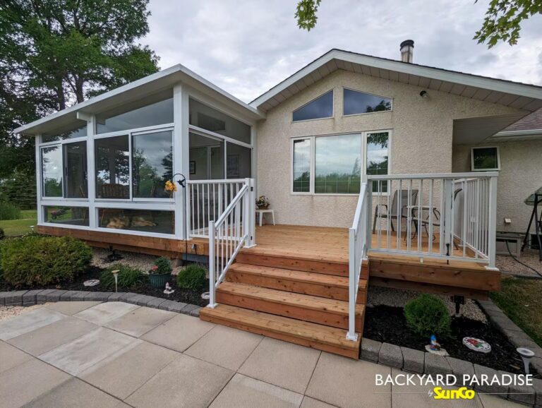 White studio sunroom with treated wood deck and white aluminum picket railings in East St Paul, Manitoba